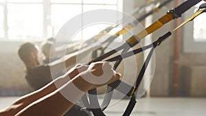 Fitness technology. Close up of hands. Woman doing fitness training exercises at industrial gym. Push-up, group workout