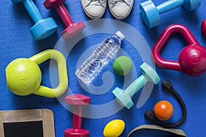 Fitness tools on blue yoga mat background