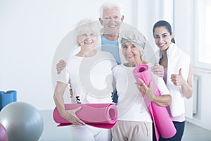 Fitness trainer congratulating elderly people photo