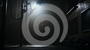 fitness training in gym at night, woman is playing with big ball, silhouette shot in darkness