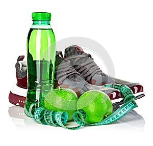 Fitness, weight loss concept with green apples, bottle of drinking water and tape measure