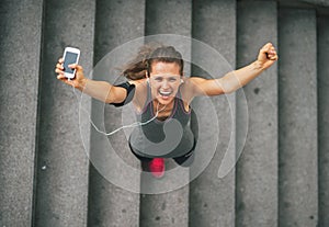 Fitness woman with cell phone outdoors in the city