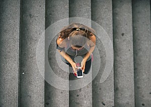 Fitness woman cell phone with outdoors in city