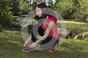 Fitness woman concentrated before sports tying her sports shoes