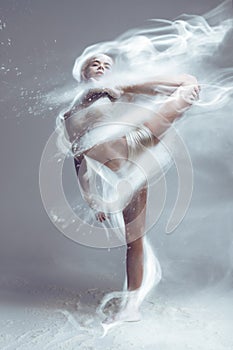 Fitness woman dancer in dust / fog