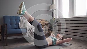 Fitness woman doing abs exercise on floor at home