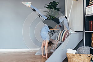 Fitness woman doing backbend stretching exercise at home, working out, handstand and one legged wheel pose.