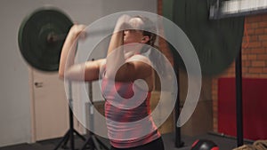 Fitness woman doing barbell thruster workout in gym