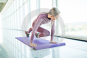 Fitness woman doing full plank with bent leg at gym, fitness in gym