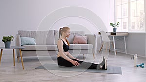 Fitness Woman Doing Hamstring Stretches Sitting On Floor At Home