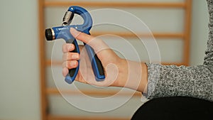 Fitness woman doing home workout with hand gripper gear,health care gym