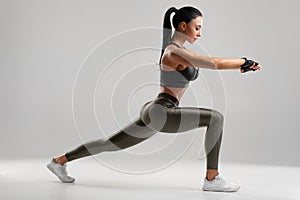 Fitness woman doing lunges exercises for leg muscle workout training. Active girl doing front forward one leg step lunge exercise