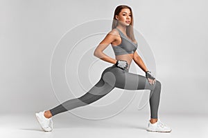 Fitness woman doing lunges exercises for leg muscle workout training. Active girl doing front forward one leg step lunge exercise