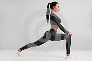 Fitness woman doing lunges exercises for leg muscle workout training. Active girl doing front forward one leg step lunge exercise