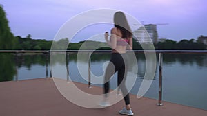 Fitness woman doing lunges on lake pier.