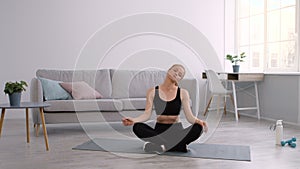 Fitness Woman Doing Neck Exercise Rotating Head Sitting At Home