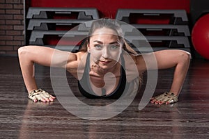 Fitness woman doing push-ups in the gym, close-up