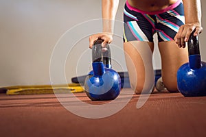 Fitness woman doing push ups with kettlebells