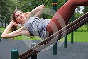 Fitness woman doing situps in outdoor gym woking out strength training