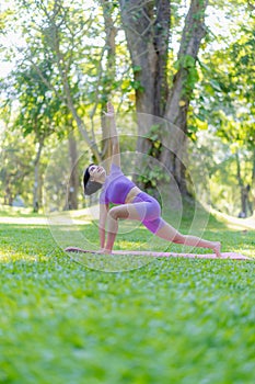 Fitness woman doing yoga in park, calm and relaxing women's happiness blurry background Asian woman