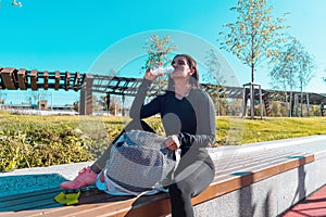 Fitness woman drinking bottled water after exercising outdoors.