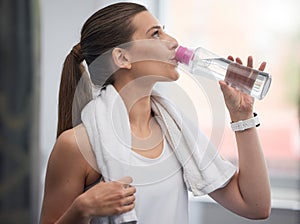 Fitness, woman and drinking water in gym for health, break and energy for workout, training or towel. Thirsty sports