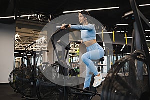 Fitness woman on exercise bike doing cardio workout.