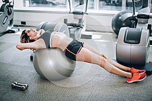 Fitness woman exercise with dumbbells and pilates ball in gym