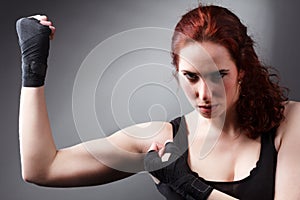 Fitness woman exercise stretch arms boxing weight punch in Dark background, studio lighting gradient gray top light