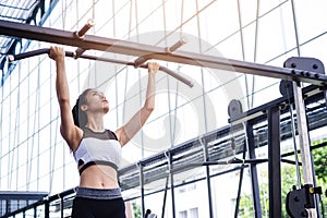 Fitness woman exercise workout with exercise-machine pull up on bar in fitness center gym. healthy lifestyle Concept