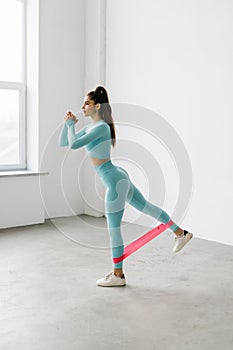 Fitness woman exercising fitness resistance bands on mattress on white background