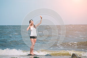 Fitness women exercising and stretching on the seacoast and making selfie