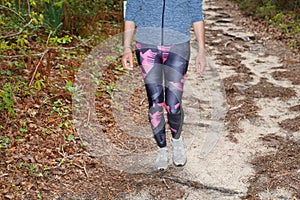 Fitness woman face slim legs fit runner jogging down an outdoor trail in city park