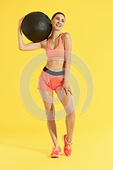 Fitness. Woman with fit body in sportswear with med ball