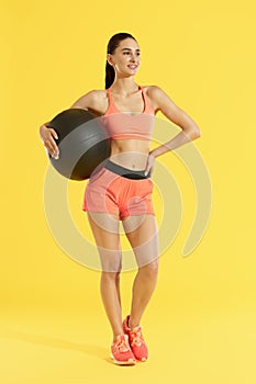 Fitness. Woman with fit body in sportswear with med ball