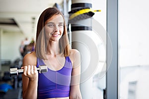 Fitness woman. Fit fitness girl smiling happy lifting weights looking strength training muscles.