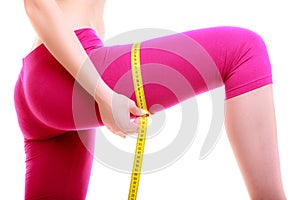 Fitness woman fit girl with measure tape measuring her thigh