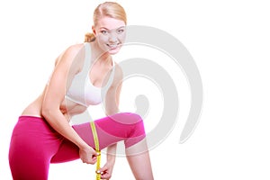 Fitness woman fit girl with measure tape measuring her thigh