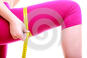 Fitness woman fit girl with measure tape measuring her thigh