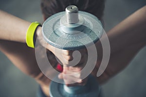 Fitness woman holding dumbbell behind head. Close up