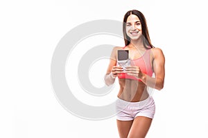 Fitness woman interrupted her diet. Portrait of young sports girl eating chocolate bar while isolated on white background.