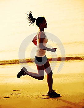 fitness woman jogging at sunrise/sunset beach