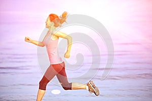 fitness woman jogging at sunrise/sunset beach