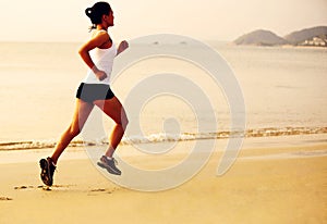 Fitness woman jogging at sunrise/sunset beach