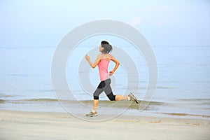 Fitness woman jogging at sunrise/sunset beach