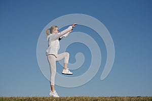 Fitness woman jumping outdoor. Adult woman in sportswear exercising in morning