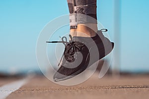 Fitness woman jumping outdoor. Exercising outside. Close up shoe and legs
