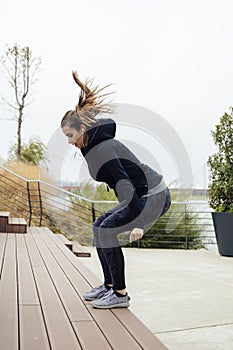 Fitness woman jumping outdoor in urban enviroment