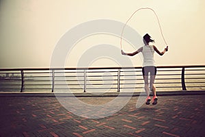 fitness woman jumping rope on seaside