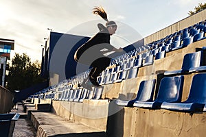 Fitness woman jumps on the stairs outdoors
